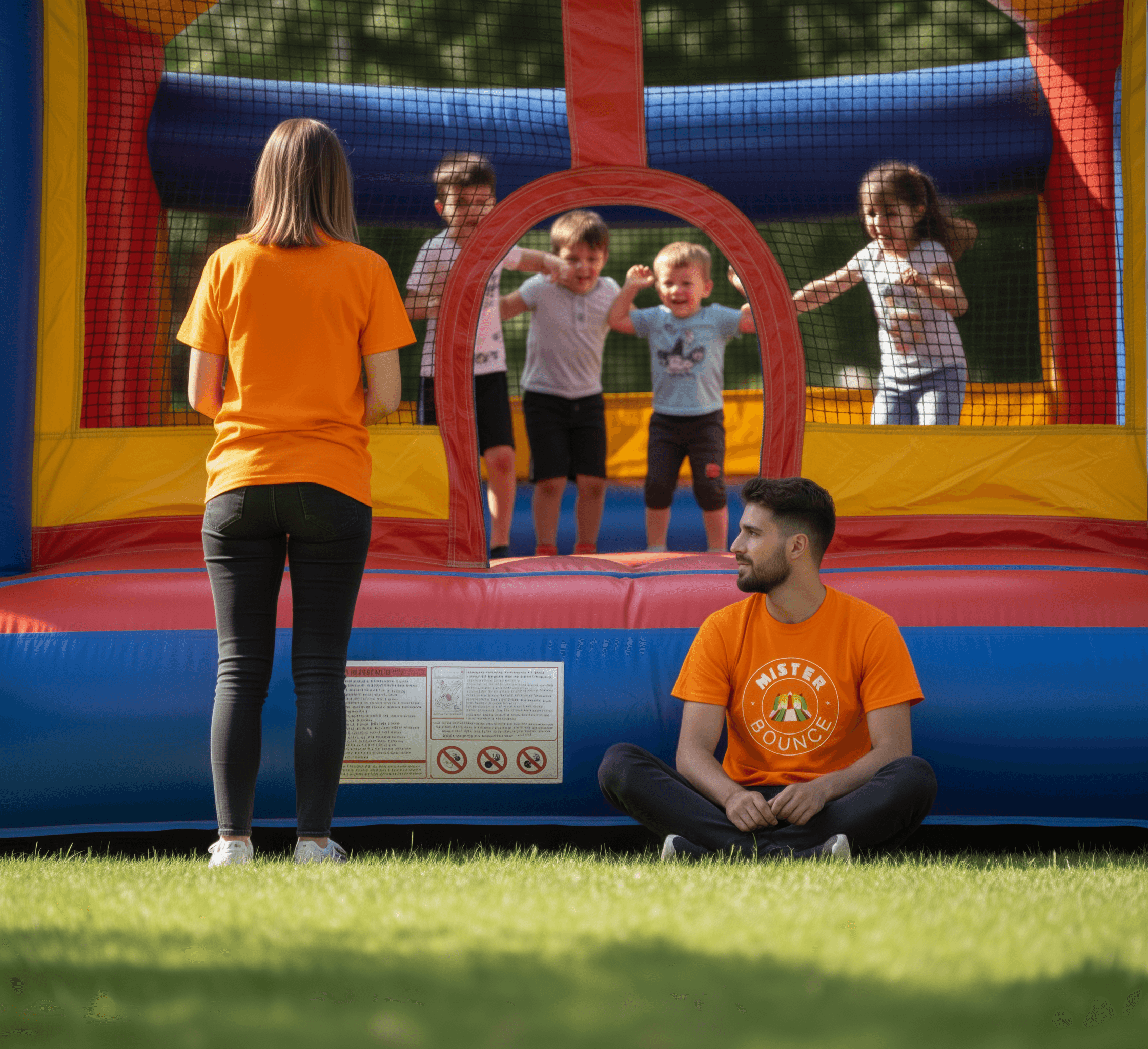 Équipe d'animateurs professionnels encadrant des enfants dans un château gonflable Mister Bounce en extérieur